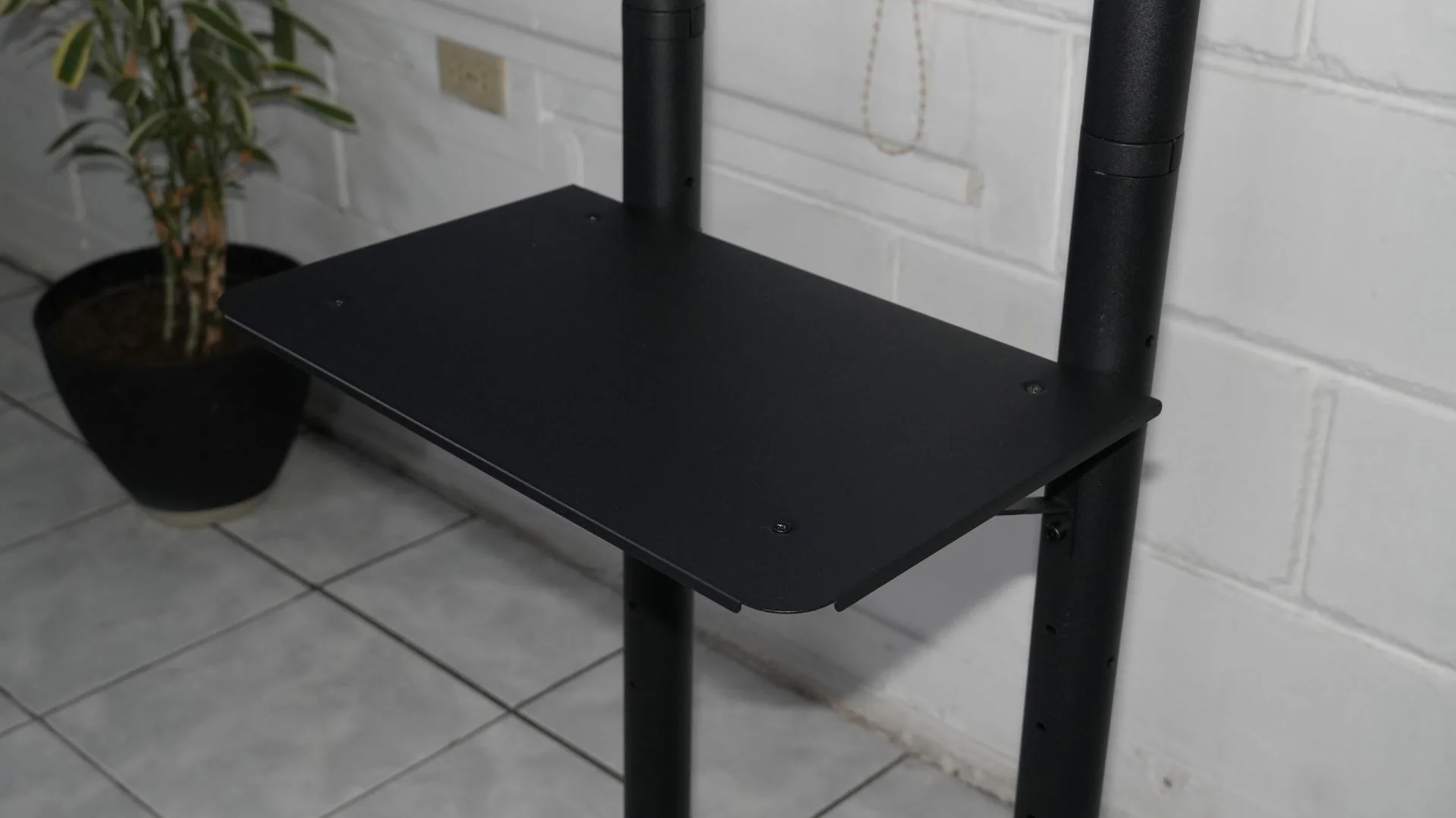 Repisa del soporte móvil para TV, montada en los postes.