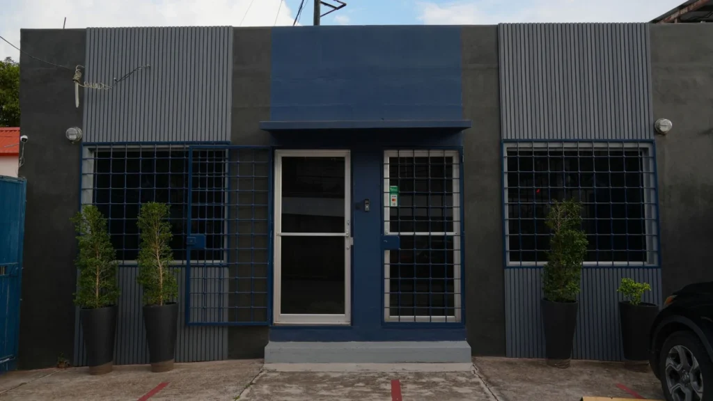 Soluciones 12 Fachada de la tienda de Bertech, con su puerta, sus ventanas enrejadas y sus plantas.